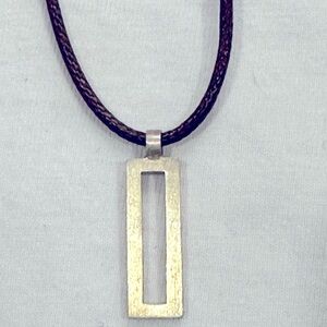 Metal rectangle pendant on leather braided cord necklace